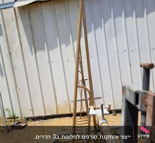מסגרת מתכתית גבוהה עם קשתות על רקע קיר מתכת